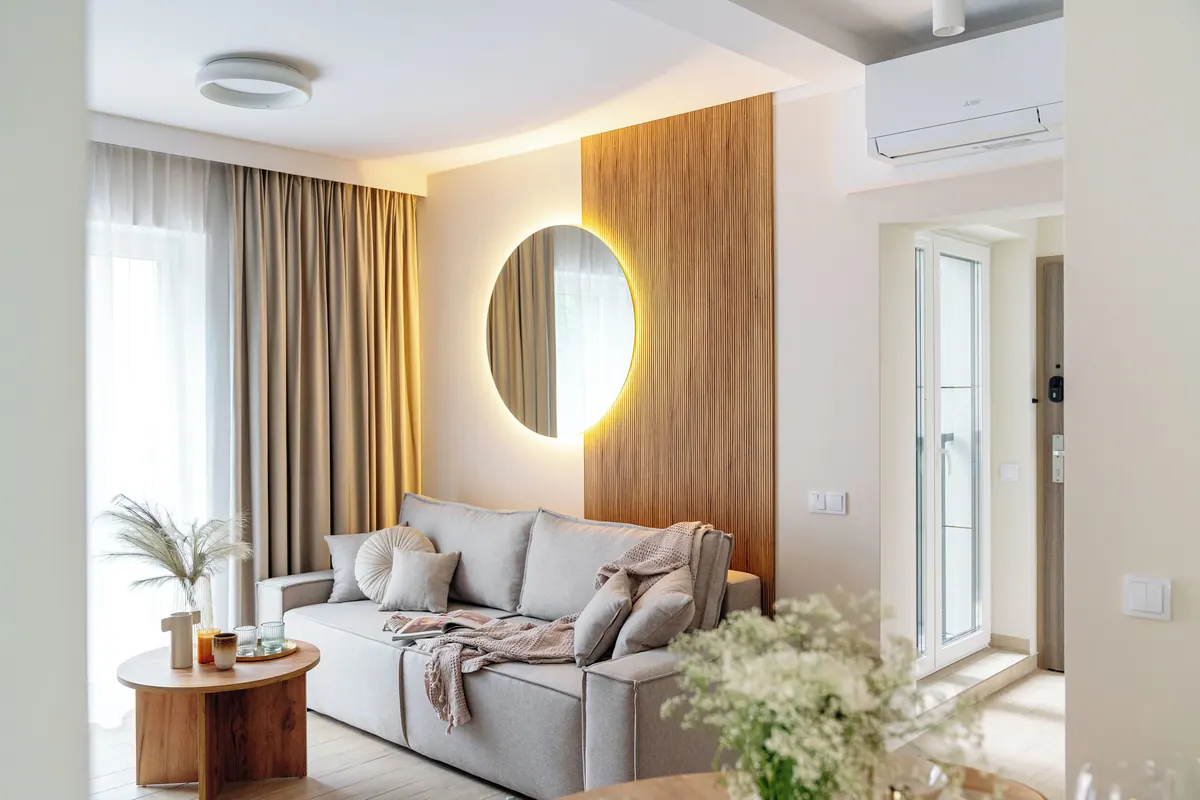 Salon apartamentu z sofą i podświetlanym lustrem